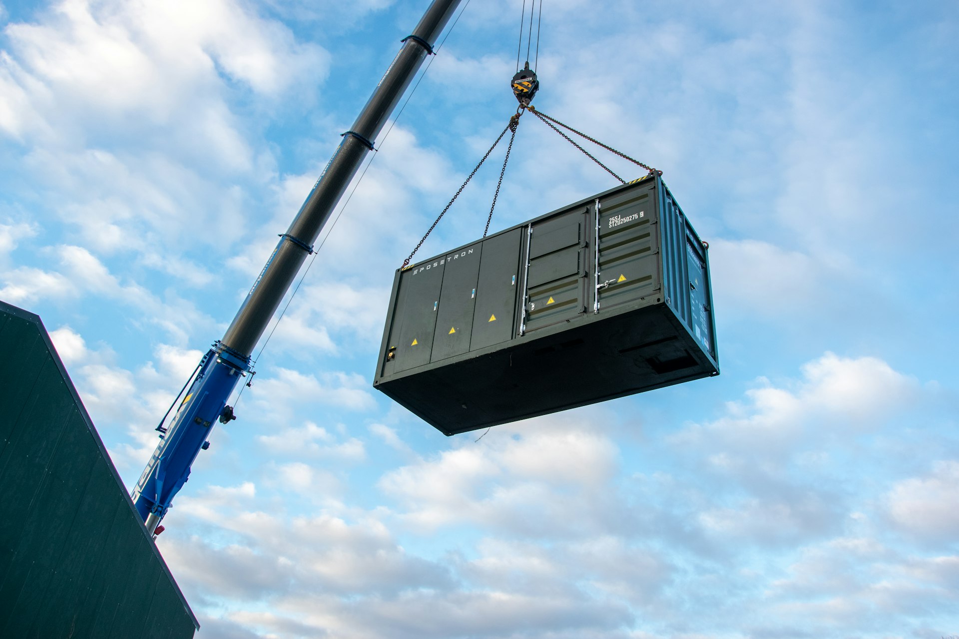 Battery storage container being craned onto a construction site.